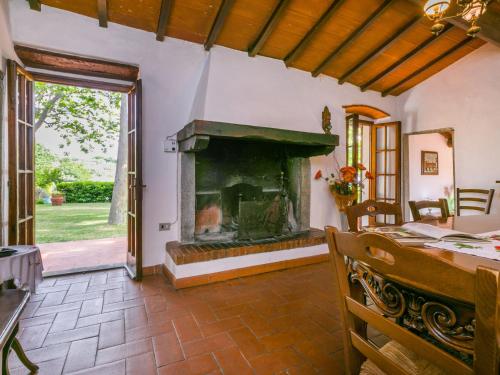 a living room with a fireplace and a dining table at Holiday Home Podere Berrettino by Interhome in Reggello