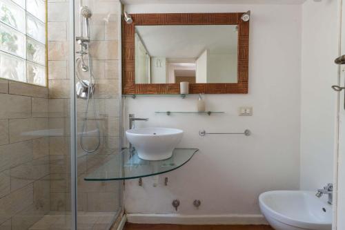 a bathroom with a glass sink and a shower at Salotto Barocco by BarbarHouse in Lecce