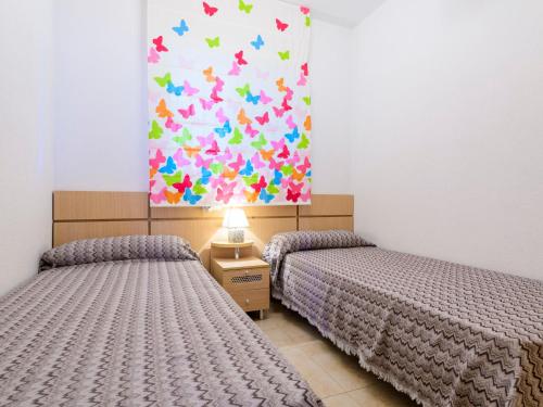 two beds in a room with a painting on the wall at Apartment Blue by Interhome in Oropesa del Mar