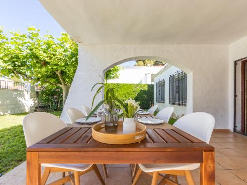 una sala da pranzo con tavolo in legno e sedie bianche di Villa Villa Valencia by Interhome a Cambrils