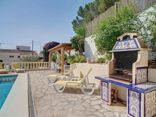 a patio with a pool and a grill next to a swimming pool at Holiday Home La Repere by Interhome in Benissa