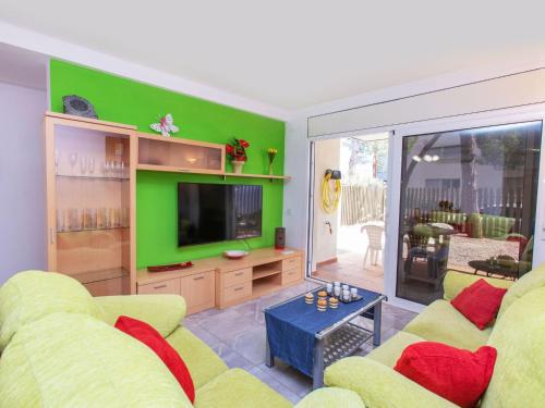 a living room with a yellow couch and a green wall at Apartment Ancora by Interhome in Platja d'Aro