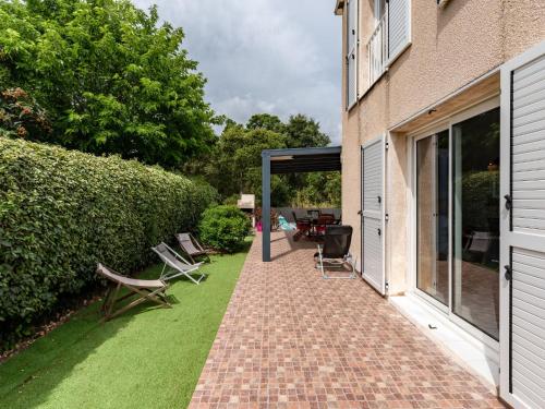 une terrasse avec des chaises sur une pelouse à côté d'un bâtiment dans l'établissement Holiday Home Maison Michel by Interhome, à Cervione