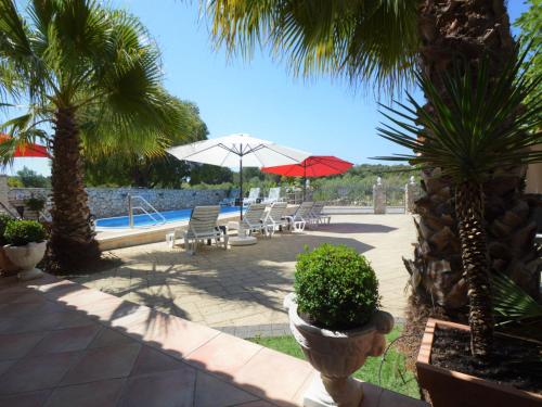 een patio met stoelen en parasols en een zwembad bij Apartment Friedrich-7 by Interhome in Tribunj