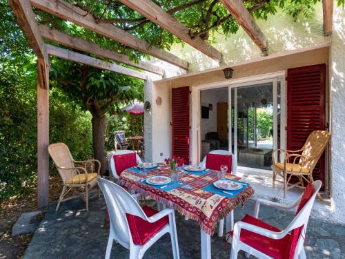 Une table à manger et des chaises sont disponibles sur la terrasse. dans l'établissement Holiday Home Villa Irène by Interhome, à Linguizzetta