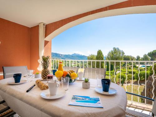 - une table avec de la nourriture et des fruits sur un balcon dans l'établissement Apartment Le Hameau - K4 124 by Interhome, à Agay
