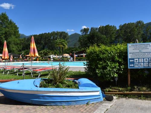 a small blue boat sitting next to a swimming pool at Holiday Home Bungalow Isola Premium by Interhome in Gudo