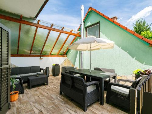 a patio with a table and chairs and an umbrella at Apartment May by Interhome in Balatonlelle