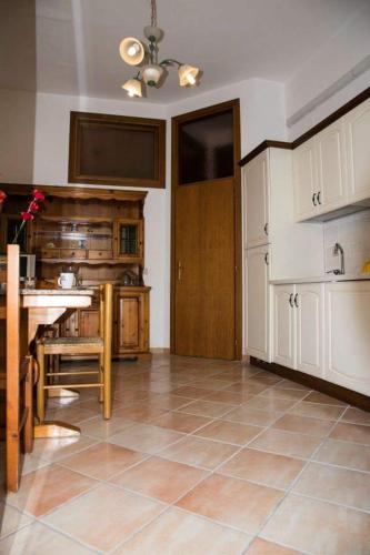 eine Küche mit einem Tisch und einer Tür in einem Zimmer in der Unterkunft Casa vacanze vicoportone in Gaeta