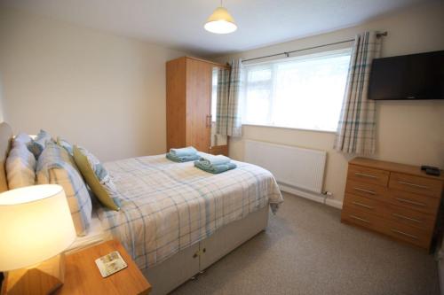 a bedroom with a bed and a window and a television at Valley Breeze in Bude