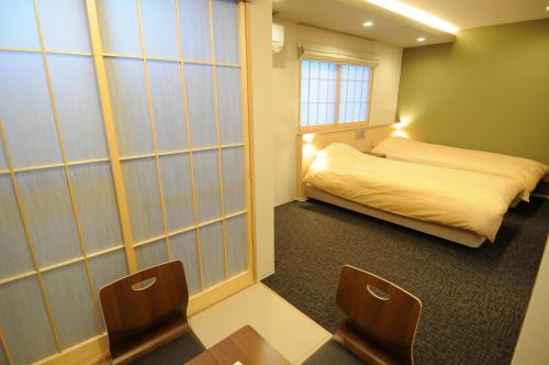 una camera con letto, tavolo e sedie di HIZ HOTEL Kyoto Nijo Castle - Vacation STAY 12551v a Kyoto