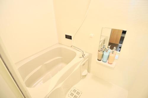 a white bathroom with a tub and a toilet at HIZ HOTEL Kyoto Nijo Castle - Vacation STAY 12567v in Kyoto