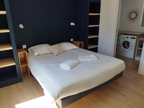 a bedroom with a bed with white sheets and pillows at La cabine du bout du monde avec Mezzanine PL04, Tevennec - votre maison de vacances de haut standing in Crozon