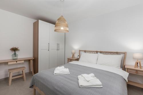 a bedroom with a bed with two towels on it at Apartments Grey, Green i White in Malinska