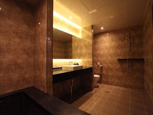 a bathroom with a sink and a toilet and a mirror at Hotel Rich in Goyang