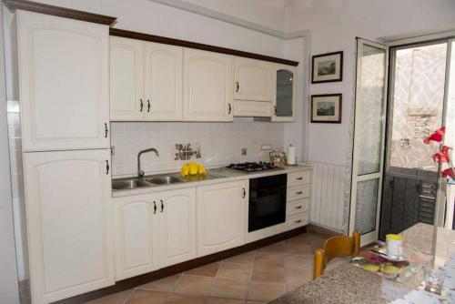 eine Küche mit weißen Schränken und einem Waschbecken in der Unterkunft Casa vacanze vicoportone in Gaeta