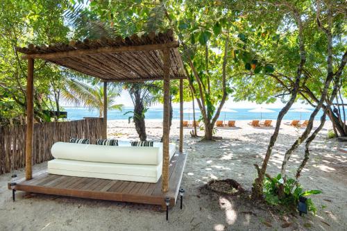 a pavilion on the beach with chairs and trees at Colibri Beach Villas in Ilha de Boipeba