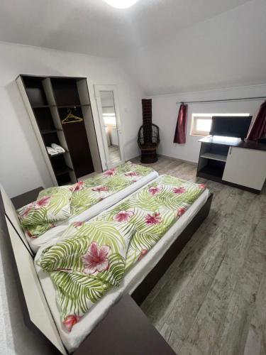 ein Schlafzimmer mit einem großen Bett mit Blumen darauf in der Unterkunft La Buna Văliug in Văliug