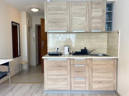 a kitchen with wooden cabinets and a sink at 09 Gdynia Centrum - Apartament Mieszkanie dla 2 os in Gdynia