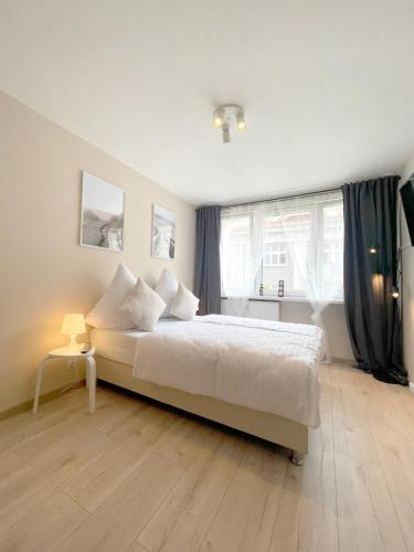 a bedroom with a large white bed and a window at 09 Gdynia Centrum - Apartament Mieszkanie dla 2 os in Gdynia