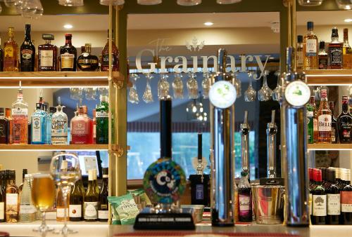 スカーバラにあるThe Grainary Boutique B&Bのアルコール飲料、時計を多数用意したバー