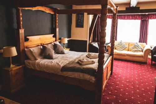 a bedroom with a bed with a wooden frame at The George Hotel, Dereham in East Dereham