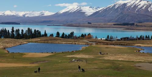 a view of a lake and snow capped mountains at The Red Hut in Lake Tekapo