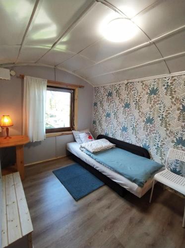 a small bedroom with a bed and a window at Przylesie Trzebciny in Trzebciny