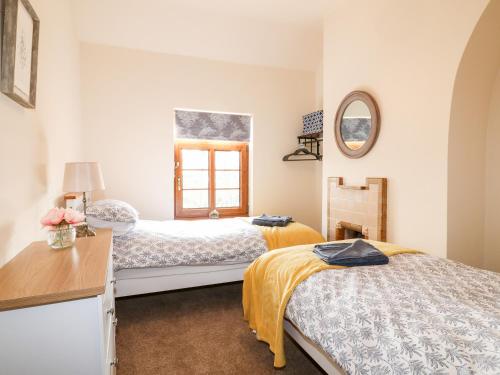 1 dormitorio con 2 camas y ventana en 13 The Island, en Totmonslow