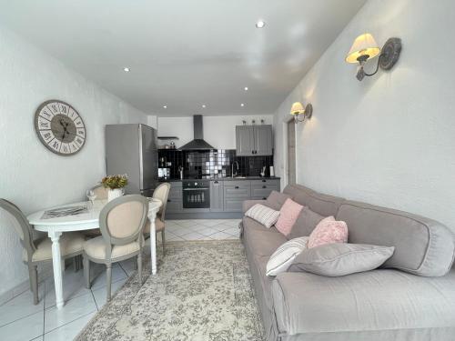 un salon avec un canapé et une table et une cuisine dans l'établissement Nice Renting - 9 MASSENA - Spacious apartment Massena Square - AC - fully equipped, à Nice