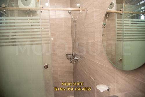 a bathroom with a glass shower with a mirror at Mojo Apartment, Tema in Tema