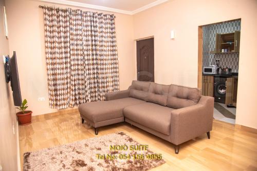 a living room with a couch and a table at Mojo Apartment, Tema in Tema