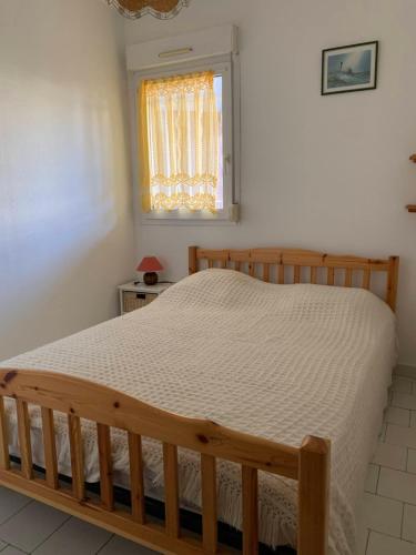 1 dormitorio con cama de madera en una habitación en Les Goêlands 3 - RDC Appt 1- Port plage rive ouest, en Frontignan