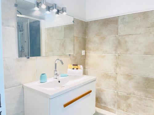 a bathroom with a white sink and a mirror at Très bel appartement face au port Santa -Piscine in Saint-Raphaël