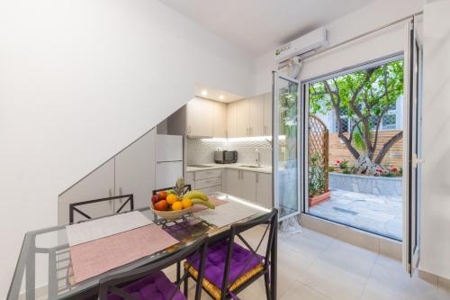 a kitchen with a table with a bowl of fruit on it at Magdalenia's cozy apartments in Nafplio