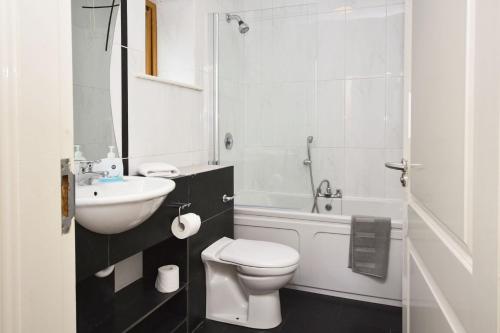 萊特弗拉克的住宿－Apartment 701 - Letterfrack，白色的浴室设有卫生间和水槽。