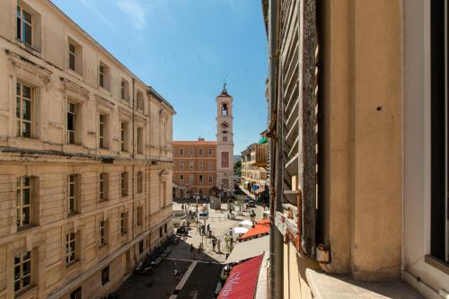 - une vue sur une rue de la ville avec une tour de l'horloge dans l'établissement Maison Bianchi - Prefecture - Old Town, à Nice