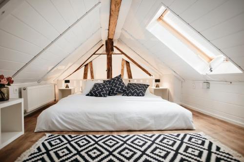 a bedroom with a white bed and a skylight at AVA HOUSE in Kranjska Gora