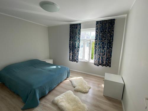 Un dormitorio con una cama azul y una ventana en Captains House - Kaptenimaja - Officers deck, en Kärdla