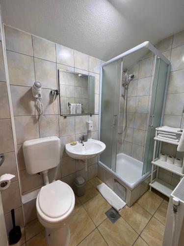 a bathroom with a toilet and a shower and a sink at Hotel Central Vlašić in Vlasic