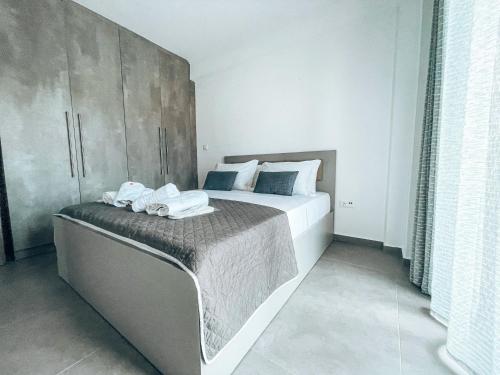 um quarto com uma cama grande e toalhas em Siblings Apartments em Nikiti