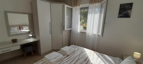 a bedroom with a bed and a desk and a mirror at Apartment Sunrise, Polje - otok Krk in Polje