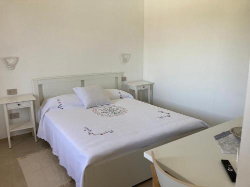 a small bedroom with a white bed and a desk at Casa Antonia in Mesagne