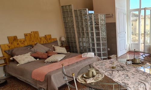 FlorensacにあるChez Dédou et Madouのベッドルーム(大型ベッド1台、テーブル付)