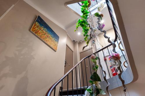 a staircase with a painting and flowers on the wall at Hotel l'Hotera in Cannes