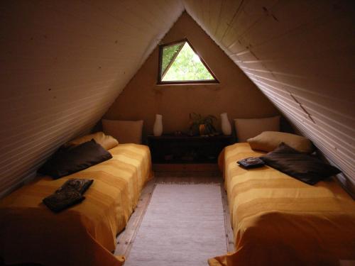 two beds in a attic room with a window at altes Schäferhaus in Mainleus