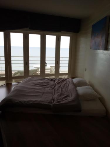 a bedroom with a large bed with a view of the ocean at Sandy Beach E18 in Cha Am