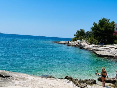 a group of people in the water at a beach at Apartmani Mate in Rogoznica