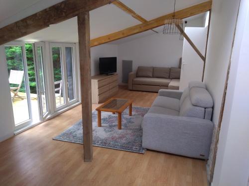 a living room with a couch and a table at Guest house aux portes du Bassin d'Arcachon in Mios