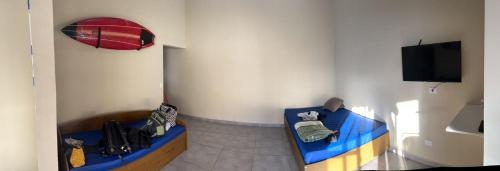 a room with two beds and a flat screen tv at Casa para aluguel de temporada em Caraguatatuba, ao lado de São Sebastião in Caraguatatuba